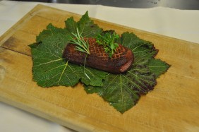 Sur le plan de travail, disposer à l’envers trois feuilles de vigne en les chevauchant légèrement et y déposer un magret